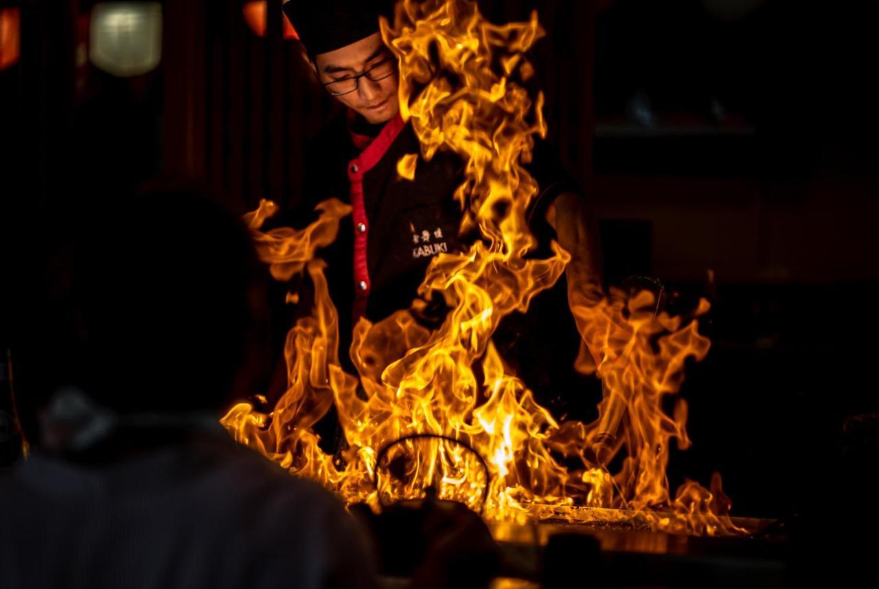 โรงแรมสแตมฟอร์ดพลาซ่าบริสเบน ภายนอก รูปภาพ A chef cooking with a flaming wok